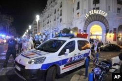 A police car is parked near the scene of an attack after a truck drove on to the sidewalk and plowed through a crowd of revelers who'd gathered to watch the fireworks in the French resort city of Nice, southern France, Friday, July 15, 2016.