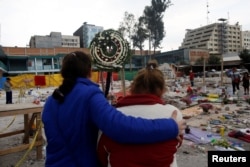Residents pray for victims at a makeshift altar, in an area that used to be a textile factory before it was destroyed in an earthquake, in Mexico City, Sept. 24, 2017.