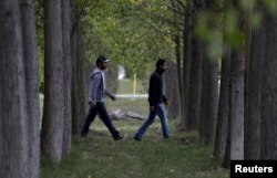 Two Syrian men walk through a temporary refugee camp in Gabcikovo, Slovakia, Oct. 8, 2015.