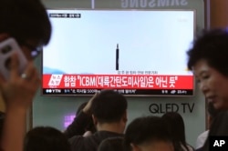 FILE - In this May 21, 2107, photo people watch a TV news program showing a file image of a missile launch conducted by North Korea, at the Seoul Railway Station in Seoul, South Korea.