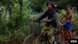 អ្នកស្រី អ៊ឹម ចែម អតីត​មេដឹកនាំ​ខ្មែរក្រហម​មួយ​រូបកំពុងជិះកង់​ជាមួយ​ចៅប្រុស កាលពីថ្ងៃទី២៣ ខែមេសា ទៅកន្លែងដាក់ចំណីឲ្យគោ ដើម្បីយកគោ​មក​ដាក់នៅចម្ការ​របស់អ្នកស្រី ក្នុងស្រុកអន្លង់វែង។ (ស៊ុន ណារិន/VOA)