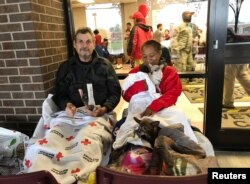 Kenneth and Minnie Bice prepare to sleep outside the M.O. Campbell Red Cross shelter in Aldine, Texas, Aug. 28, 2017. Pets are not allowed inside, so the two are sleeping on the portico with their two dogs and one cat.