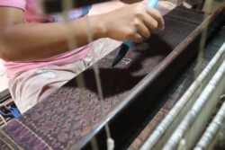 អ្នកតម្បាញនៅអង្គការវិទ្យាស្ថានវាយនភណ្ឌប្រពៃណីខ្មែរ Institute of Khmer Traditional Textiles កំពុងត្បាញហូលបុរាណខ្មែនៅក្នុងស្រុកអង្គរធំ ខេត្តសៀមរាប កាលពីថ្ងៃទី២១ ខែកក្កដា ឆ្នាំ២០២០។ (ផនបុប្ផា/វីអូអេ)