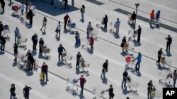 មនុស្សម្នា​ឈរ​តម្រង់​ជួរ​រង់ចាំ​ចូល​ផ្សារ​ទំនើប Esselunga នៅ​ជាយ​ក្រុង Milan ប្រទេស​អ៊ីតាលី កាលពី​ថ្ងៃទី១១ ខែមេសា​ ឆ្នាំ២០២០។