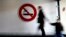 FILE - A woman and child walk past a "No Smoking" sign. A Yale-led study has found that nicotine exposure during pregnancy can trigger long-term genetic changes in unborn babies.