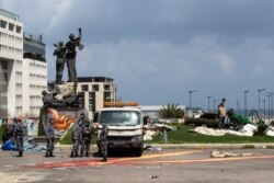 FILE - Lebanese policemen remove protesters' tents in Martyrs Square in Beirut, March 28, 2020.