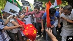 Para demonstran India membakar bendera China dalam protes di New Delhi (1/5) setelah tentara China dilaporkan melanggar perbatasan dan masuk ke wilayah India di Ladakh di kawasan Himalaya.