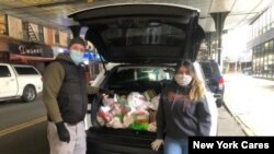 Chris Porr and his wife making food deliveries in Jackson Heights, Queens, New York. (Photo by New York Cares)