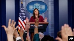 អ្នក​សារព័ត៌មាន​លើក​ដៃ​ដើម្បី​សួរ​សំណយរ​ទៅ​អ្នកស្រី Sarah Huckabee Sanders ក្នុង​សន្និសីទ​កាសែត​ប្រចាំ​ថ្ងៃ​ នៅ​សេតវិមាន កាលពី​ថ្ងៃទី១០ ខែមេសា ឆ្នាំ២០១៨។