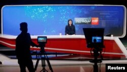 FILE - An anchor at Tolo TV delivers the news at the station's studio, in Kabul, Afghanistan, Sept. 7, 2018.