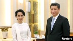 លោក​ប្រធានាធិបតី Xi Jinping និង​លោកស្រី អង់សាន ស៊ូជី ឈរ​ថត​រូប​ក្នុង​កិច្ចប្រជុំ​របស់​ពួកគេ​នៅ​វិមាន Great Hall of the People នៅ​ក្នុង​ក្រុង​ប៉េកាំង ប្រទេស​ចិន កាលពី​ថ្ងៃទី១១ ខែមិថុនា ឆ្នាំ២០១៥។