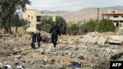 A man and two children walk above debris at the site of an overnight Israeli airstrike in the eastern Lebanese village of al-Qasr, on Nov. 11, 2024. 