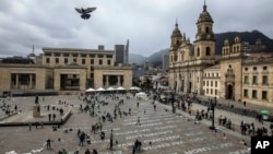 FILE - Activists who have received death threats display the names of killed leftist activists as part of an art installation by Colombia artist Doris Salcedo at Plaza Bolivar in downtown Bogota, Colombia, June 10, 2019. 