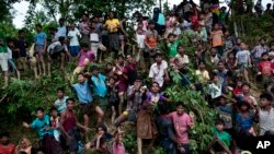 20일 방글라데시 콕스바자르의 난민수용소에서 로힝야족 난민들이 구호품을 받기 위해 손을 뻗고 있다.