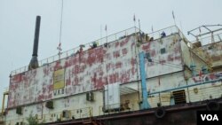 The Apung 1 barge, which was generating electricity offshore, was carried five kilometers by the tsunami and came to rest atop two houses. (Steve Herman/VOA News)