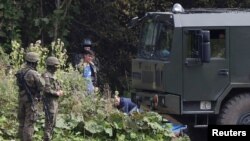FILE - Polish border patrol officers are pictured near a group of migrants stranded on the border between Belarus and Poland near the village of Usnarz Gorny, Poland, August 23, 2021. 