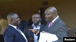 Roger Lumbala (R), a former member of parliament in the Democratic Republic of Congo who joined the M23 rebel group, chats with colleagues shortly after attending a peace talk meeting in Uganda's capital Kampala, January 11, 2013.