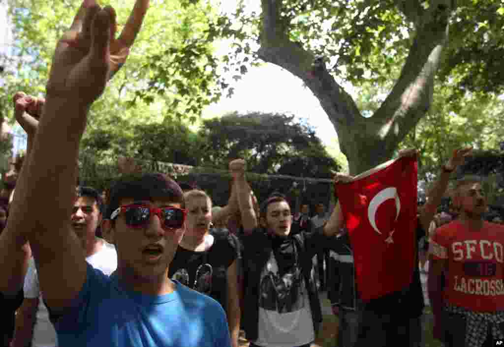 Siswa-siswa sekolah menengah atas menyanyikan lagu kebangsaan Turki dalam protes di Taman Gezi dekat Alun-Alun Taksim, Istanbul (3/6). (AP/Thanassis Stavrakis)&nbsp;