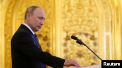 普京在莫斯科克里姆林宫举行的就职典礼上手按宪法第四次宣誓就任俄罗斯总统。（2018年5月7日）