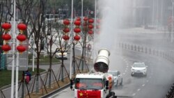 武汉工人在街道上喷洒消毒药水以抗击新冠疫情。（2020年2月10日）