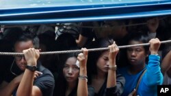 Morning commuters ride a water taxi along a busy canal early in Bangkok, Thailand.