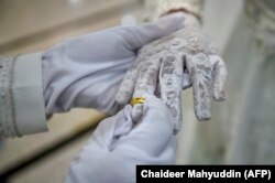 Seorang pengantin pria memasang cincin di jari istrinya saat upacara pernikahan di sebuah masjid di Banda Aceh pada 3 Juni 2020. (Foto: AFP/Chaideer Mahyuddin)
