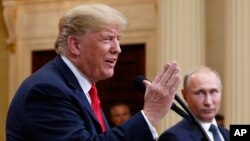 U.S. President Donald Trump speaks with Russian President Vladimir Putin during a press conference after their meeting at the Presidential Palace in Helsinki, Finland, July 16, 2018. 