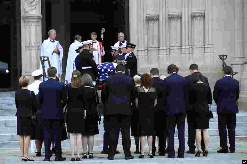 Family members of Sen. John McCain, are gathered as his casket arrives on the steps of the Washington National Cathedral in Washington, Sept. 1, 2018, for a memorial service. 