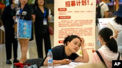 Seorang perekrut berbicara dengan pelamar di stan bursa kerja di sebuah pusat perbelanjaan di Beijing, Jumat, 9 Juni 2023. (Foto: AP/Mark Schiefelbein)