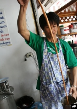 Suchart Lapaparat pours hot tea at his store inside the red shirt protest zone in central Bangkok. He says he is losing money from the protests.