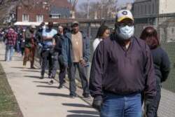 FILE - Voters observe social distancing guidelines as they wait in line to cast ballots in the state's presidential primary election, in Milwaukee, Wisconsin, April 7, 2020.