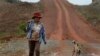 A Cambodian woman carries a long-handled machete as she travels on a road in Thmey village, Koh Kong province, about 250 kilometers (155 miles) west of Phnom Penh, file photo. 