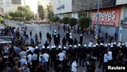 A formation of Palestinian police stands ahead of demonstrators during a protest over the death of Nizar Banat, a critic of the Palestinian Authority, in Ramallah in the Israeli-occupied West Bank, June 26, 2021. 