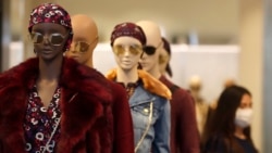 A staff member of a retail store wears a face mask in London, Tuesday, Sept. 22, 2020. British Prime Minister Boris Johnson has slammed the brakes on the country's return to offices, saying people should work from home if possible to help slow the spread