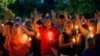 People hold up their hands in prayer during a candlelight vigil for fallen Baton Rouge police officers at the Healing Place Church in Baton Rouge, Monday, July 18, 2016.