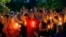 People hold up their hands in prayer during a candlelight vigil for fallen Baton Rouge police officers at the Healing Place Church in Baton Rouge, Monday, July 18, 2016.
