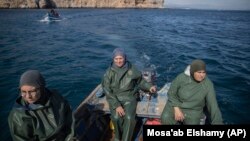 In this Feb. 12, 2020 photo, Fatiha Naji, right, Fatima Mekhnas, center, and Saida Fetouh, left, members of the first Moroccan female fishing cooperative go out to sea in a fishing boat on the coast of the Mediterranean, northern Morocco. (AP Photo/Mosa'ab Elshamy)