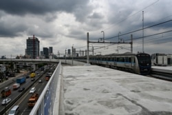 Kereta Moda Raya Terpadu (MRT) Jakarta melintas di atas jalan raya setelah peresmian, 12 Maret 2019. (Foto: AFP)