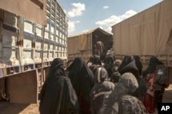 Women and children board a truck at a reception area for people evacuated from the last shred of territory held by Islamic State militants, outside Baghuz, Syria, March 6, 2019.