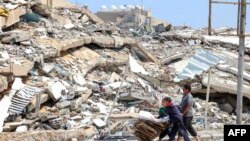 Anak-anak Palestina tampak mengumpulkan kardus dan palet kayu di wilayah Beit Lahya di Gaza Utara, pada 4 Mei 2024. (Foto: AFP)