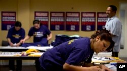 Denise Villagomez, a union member, writes on a sign as she and other volunteers prepare for Wednesday's immigration reform rally at the Service Employees International Union, which is co-organizing the event, in Washington, April 9, 2013. 
