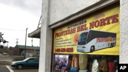 FILE - A sign advertising bus trips to California with connections to Mexico, at a shop in the predominantly Latino town of Woodburn, Ore., March 2, 2017.