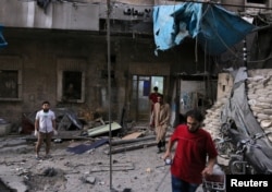 Medics inspect the damage outside a field hospital after an airstrike in the rebel-held al-Maadi neighbourhood of Aleppo, Syria, Sept. 28, 2016.
