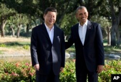 FILE - President Barack Obama stands with Chinese President Xi Jinping at the Annenberg Retreat at Sunnylands as they meet for talks in Rancho Mirage, California, June 7, 2013.