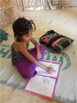 Grade 1 Learner Using Workbook at home in Rohingya Refugee Camp, Cox's Bazar, Bangladesh