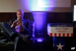 Mark Gilbert, U.S. ambassador to New Zealand, checks election results on his phone in Wellington, New Zealand, Nov. 9, 2016. Gilbert was appointed by President Barack Obama and has been told by the Trump transition team to be out by Jan. 20.