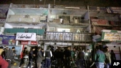 Orang-orang berkumpul di depan mall di Baghdad, Irak, 11 Januari 2016. Pria bersenjata menyerbu mall tersebut dan melepaskan tembakan kepada pengunjung mall sebelum meledakkan diri.