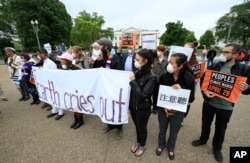 Religious leaders and others gather outside the White House in Washington during a demonstration to admonish Trump administration actions on the climate, April 19, 2017.