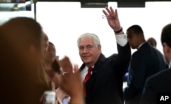 FILE - Outgoing Secretary of State Rex Tillerson waves goodbye as he walks out of the doors of the State Department in Washington, March 22, 2018, after speaking to employees upon his departure.