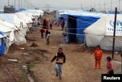 FILE - Displaced Iraqi children, who fled from Islamic State violence in Mosul, play in refugee camp on the outskirts of the Kurdish city of Irbil, Dec. 1, 2014.